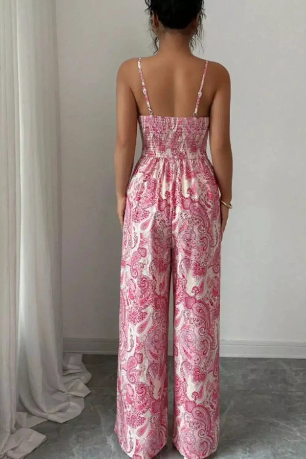 Paisley Print Wide Leg Jumpsuit in pink with smocked back and spaghetti straps.