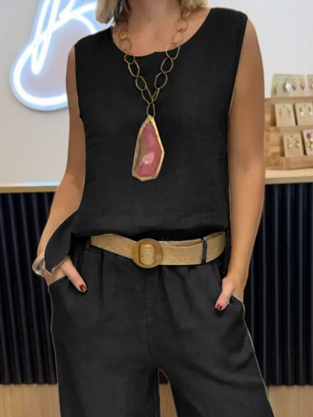 Plus-size black round-neck tank and pants set with beige belt and pink pendant necklace