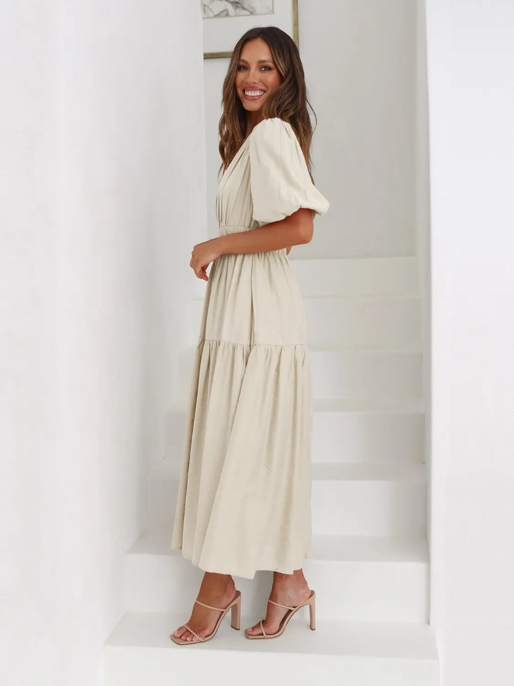 Tiered surplice midi dress in cream with short puff sleeves; non-stretch fabric.