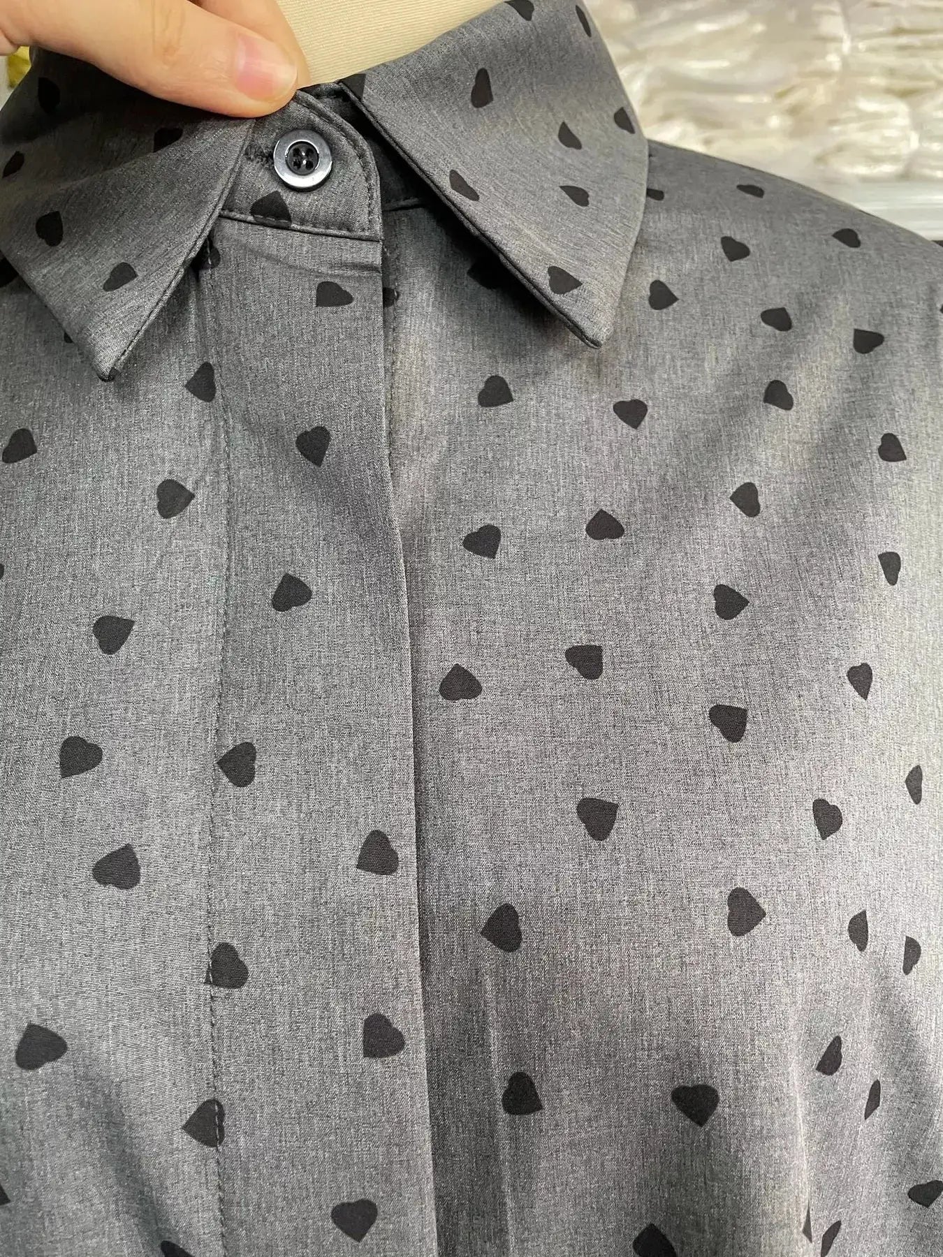 Heart print gray button-up shirt with collar featuring small black hearts on fabric
