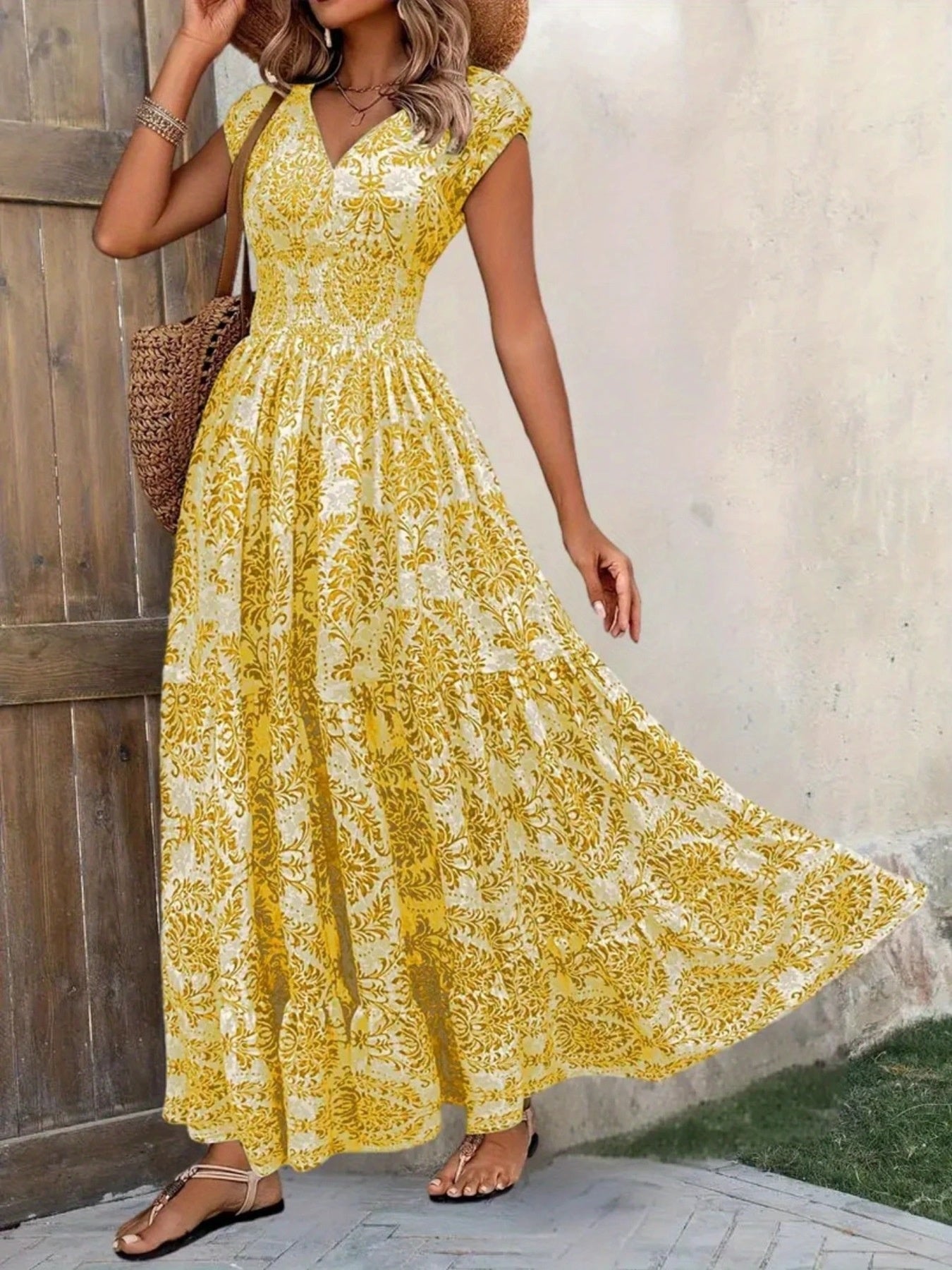 Printed cap-sleeve maxi dress in white fabric with yellow damask print, tiered and smocked.
