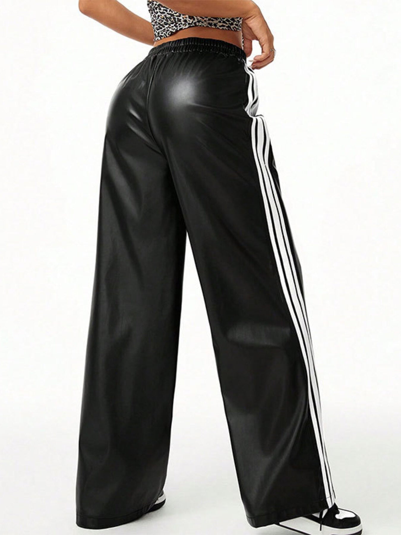 Striped wide-leg pants in black faux leather with white side stripes