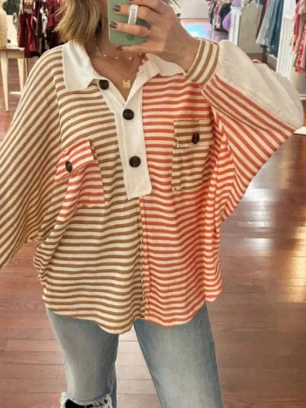 Striped oversized half-button sweatshirt in tan and pink with white collar placket and large dark buttons.