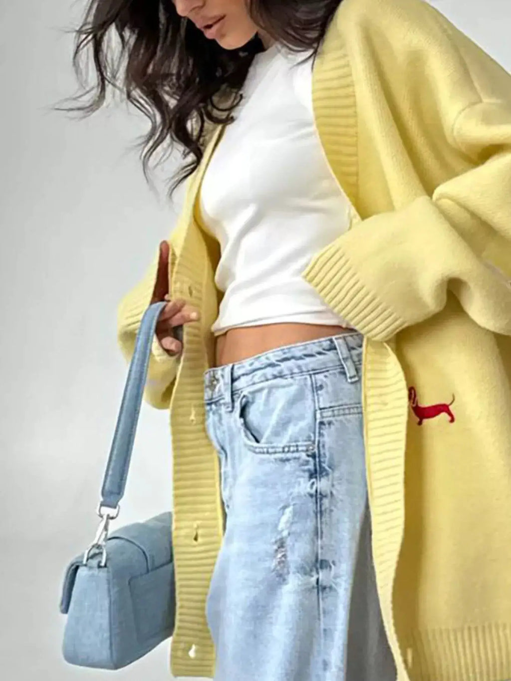 Embroidered Button Up Cardigan in yellow with red dog motif; oversized knit worn over white top with light-wash jeans