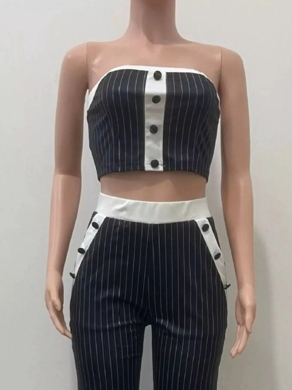 Striped strapless crop top and wide-leg pants set in navy with white center panel and button accents.