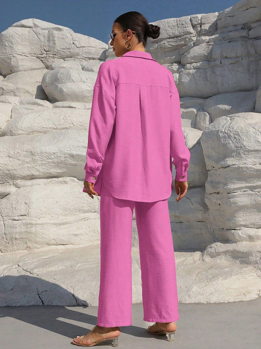 Button Up Long Sleeve Shirt and Pants Set in pink, back view on model wearing matching wide-leg pants by Trendsi.