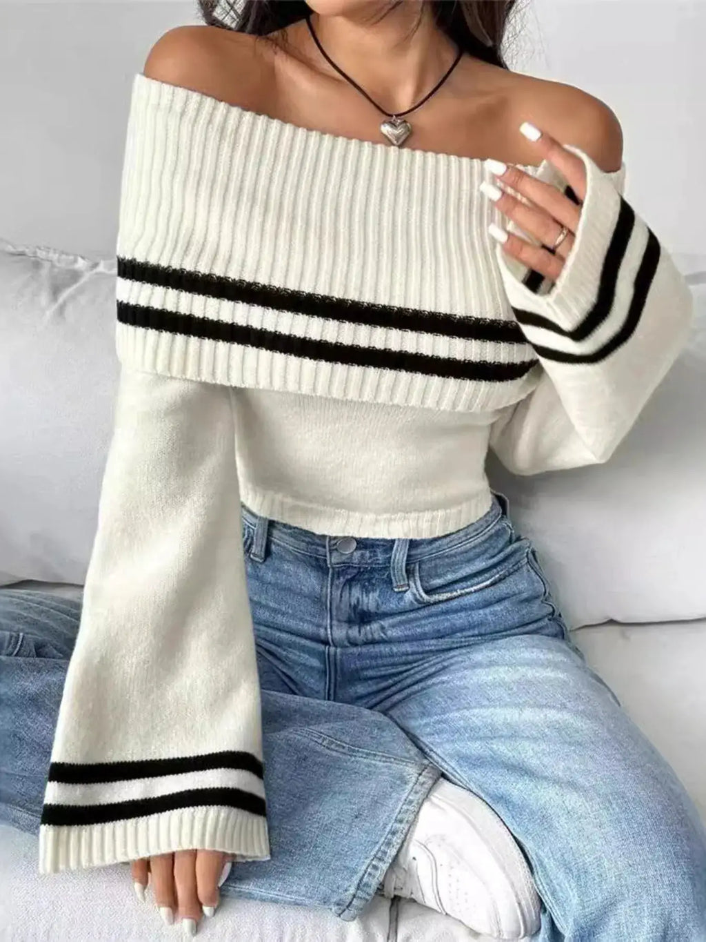 White ribbed off-shoulder knit top with black stripe bands across chest and cuffs