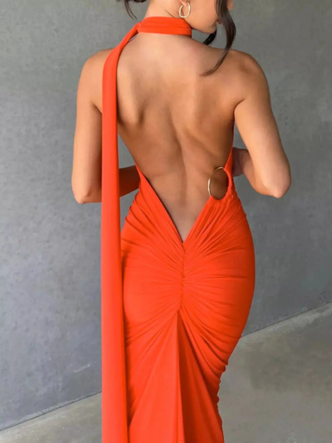 Backless One-Shoulder Ruched Bodycon Maxi Dress in bright orange-red with scarf strap and metal ring at back.