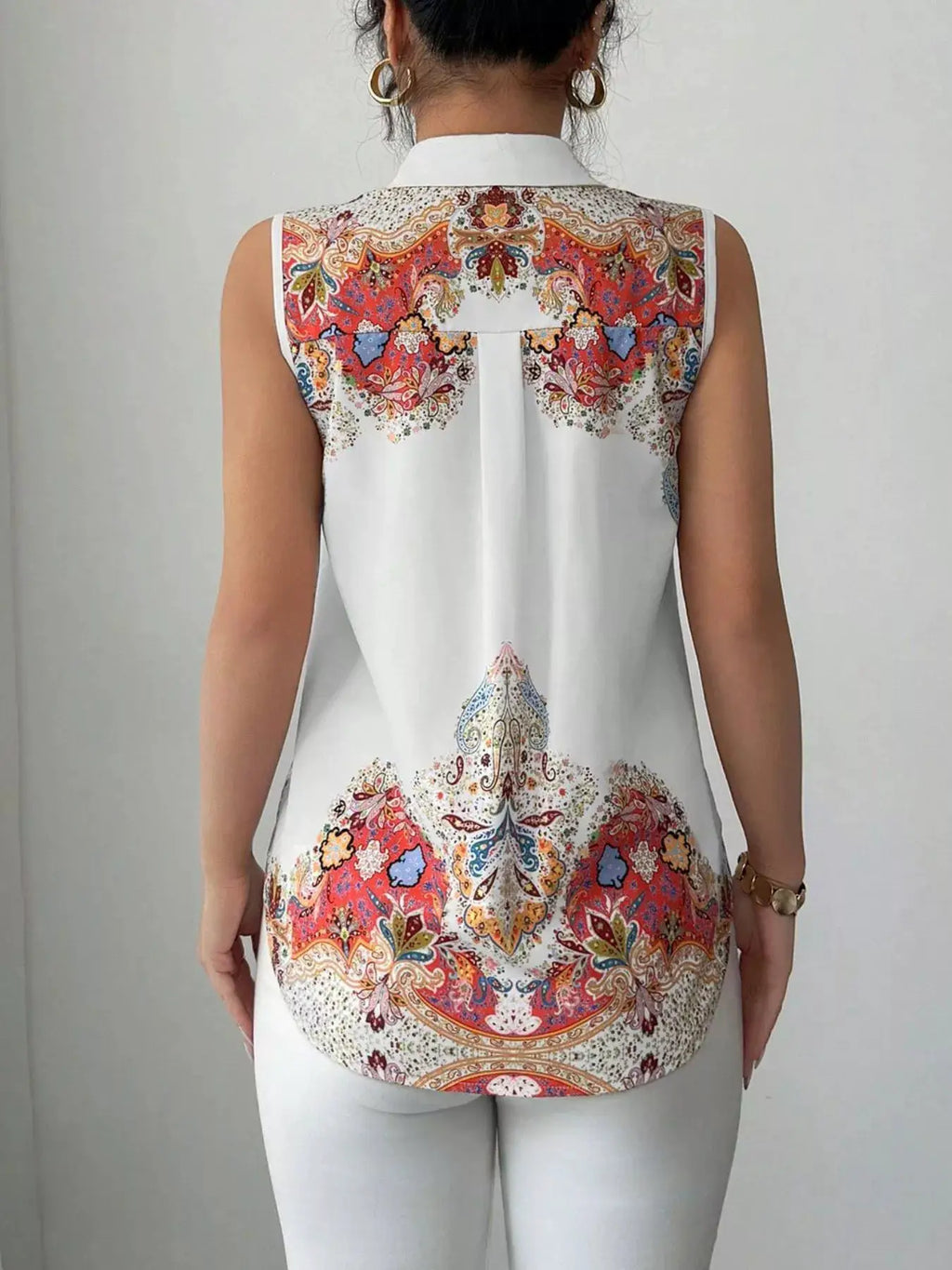Button Up Sleeveless Shirt in white with vivid multicolor paisley print on the yoke and hem.