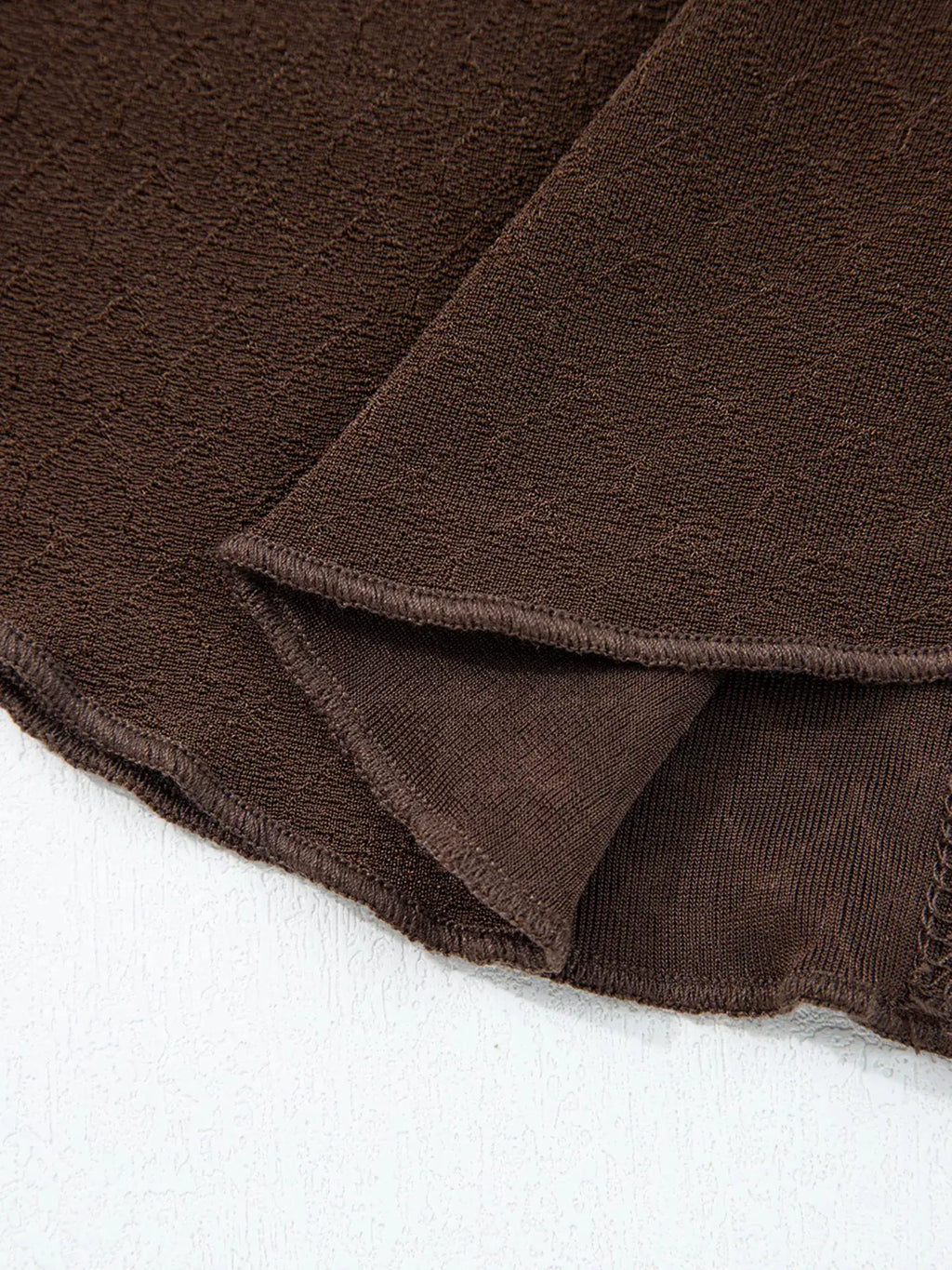 Lettuce Trim Raw Seam Patchwork Jacquard Long Sleeve Top in brown textured knit, close-up hem detail