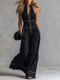 Zip-front sleeveless black jumpsuit with wide-leg pants and white contrast stitching