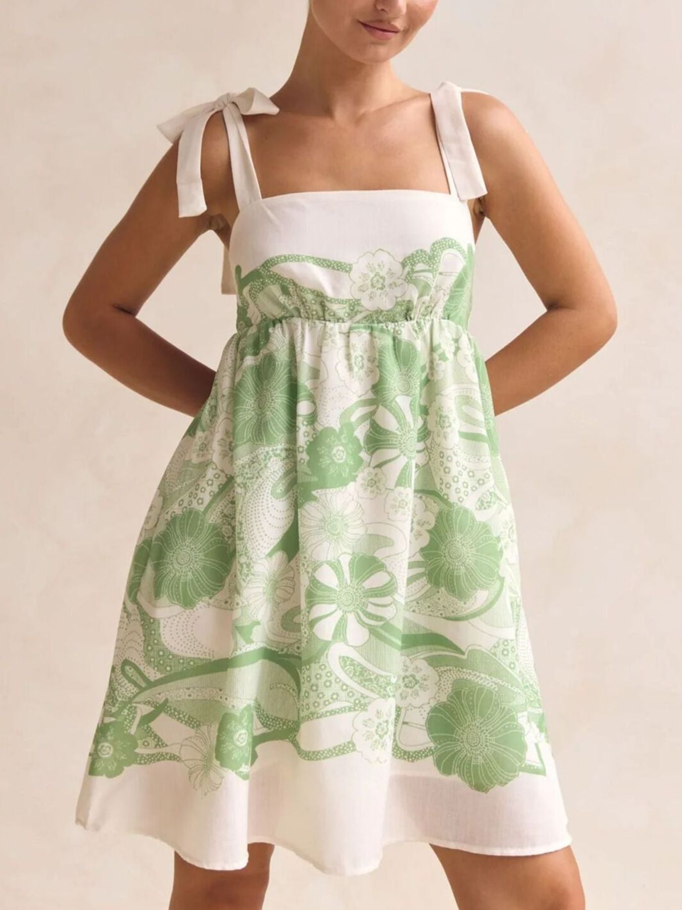 Printed Tie-Shoulder Mini Dress by Belle Bijouix in green floral print with tied straps, smocked bodice, pockets