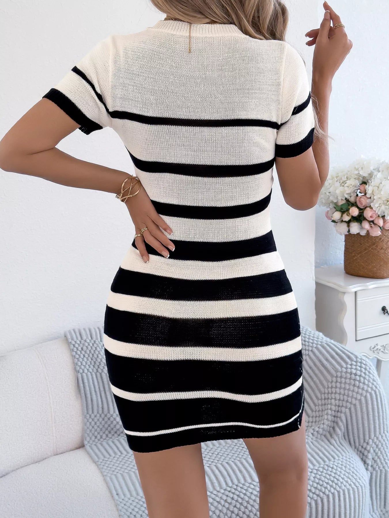Striped Bodycon Knit Mini Dress in white with black stripes, ribbed knit fabric (back view).