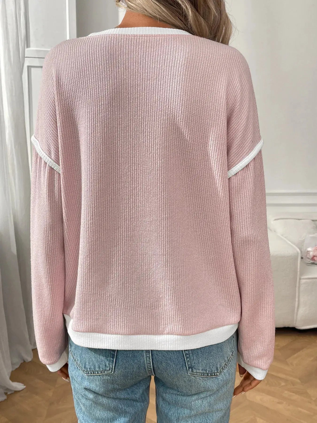 Ribbed pink long-sleeve top with white contrast trim at cuffs and hem, back view.