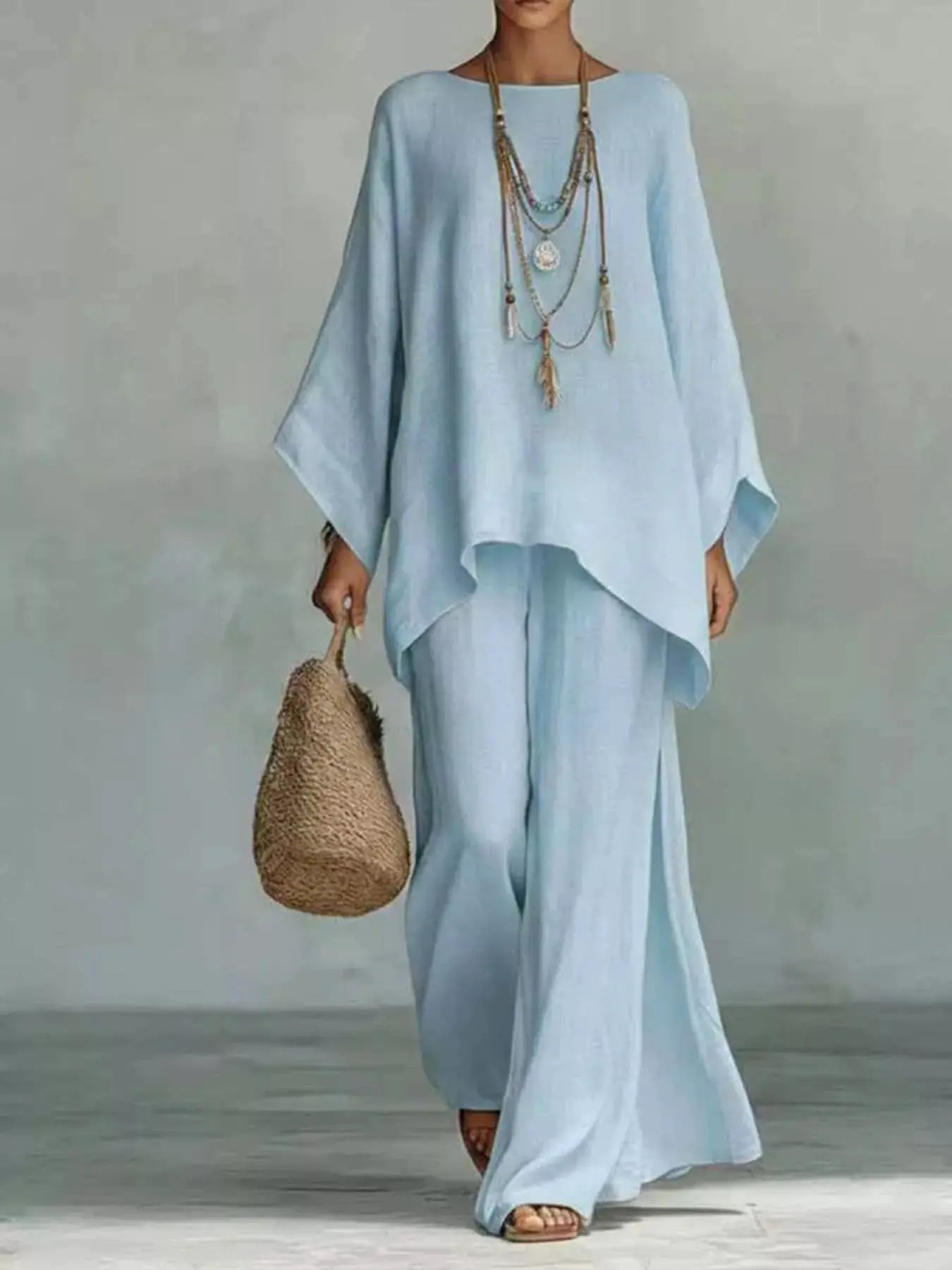 Plus-size two-piece outfit set in light blue with a round-neck top and wide-leg pants by Belle Bijouix.