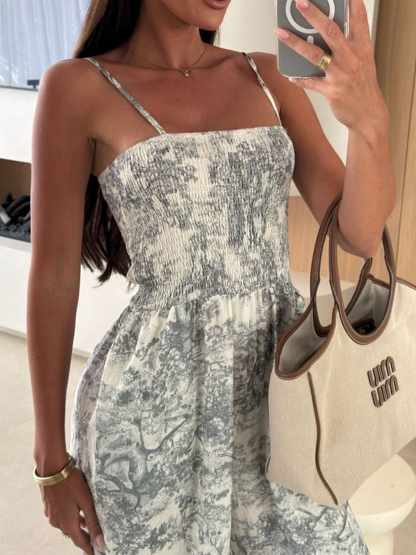Printed smocked wide-leg jumpsuit with spaghetti straps in a gray-blue print.