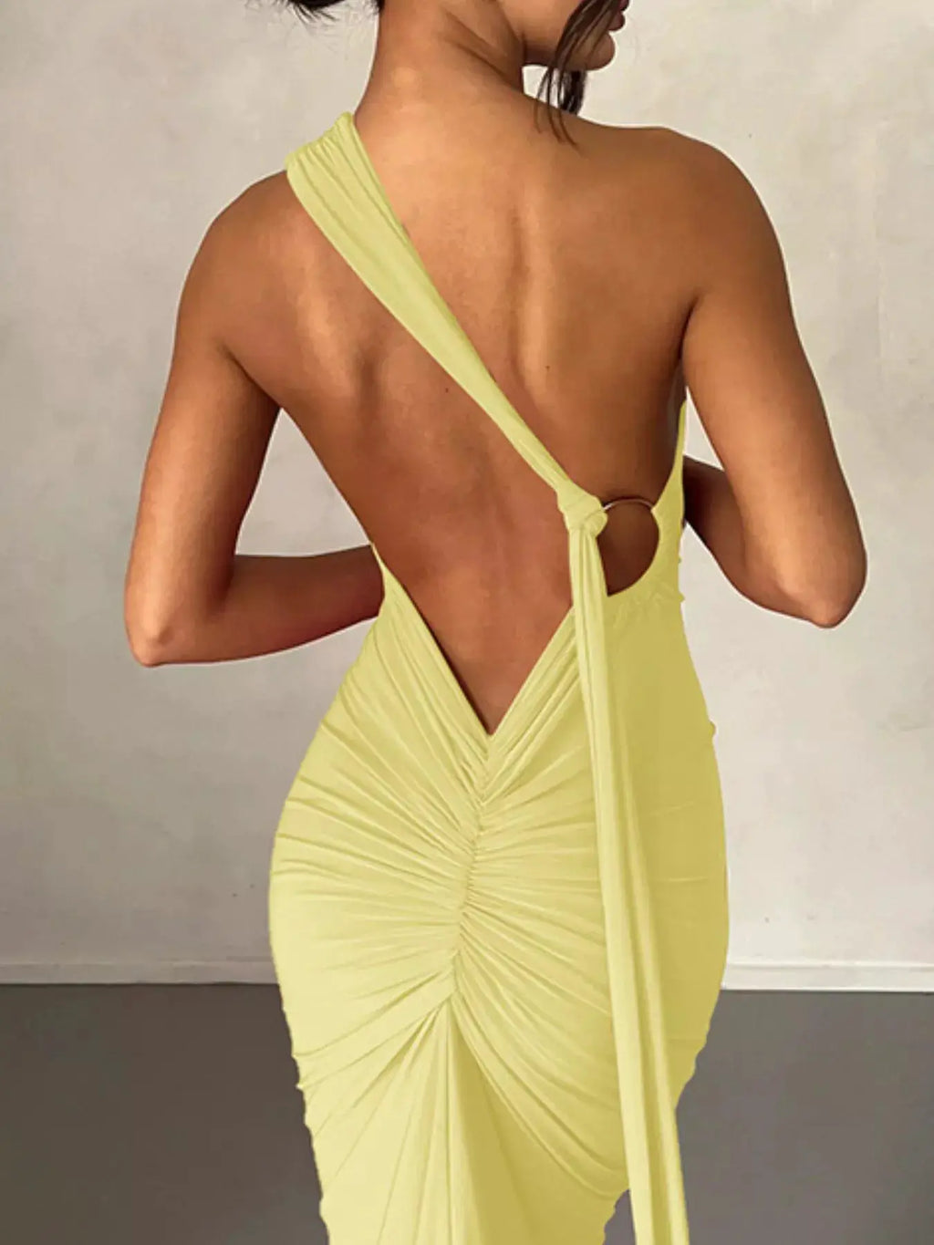 Backless One-Shoulder Ruched Bodycon Maxi Dress in yellow; single strap, back knot, ruching for a sleek evening look.