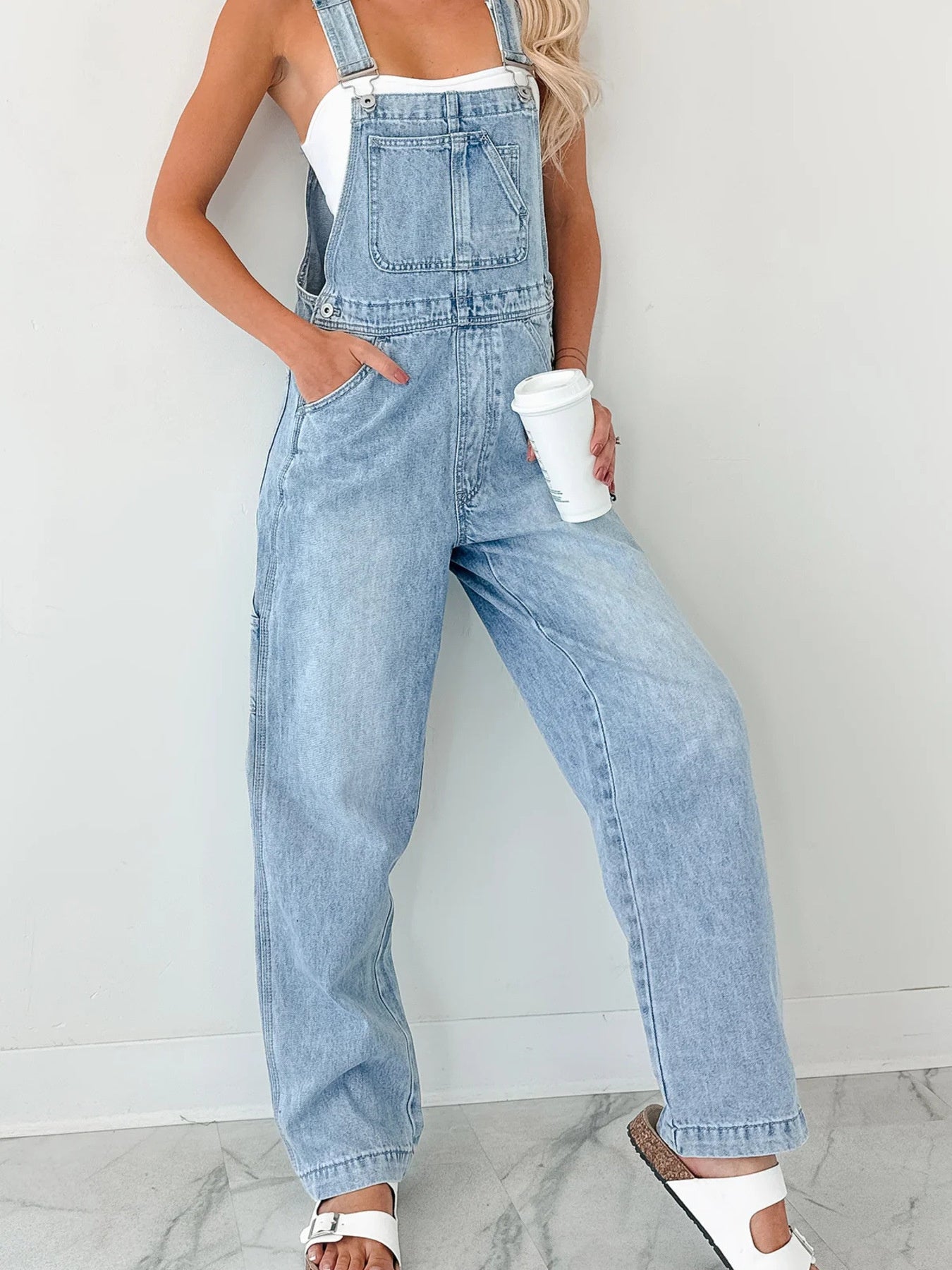 Wide Strap Relaxed Fit Denim Overalls by Trendsi in light wash with front pocket, worn over a white top.