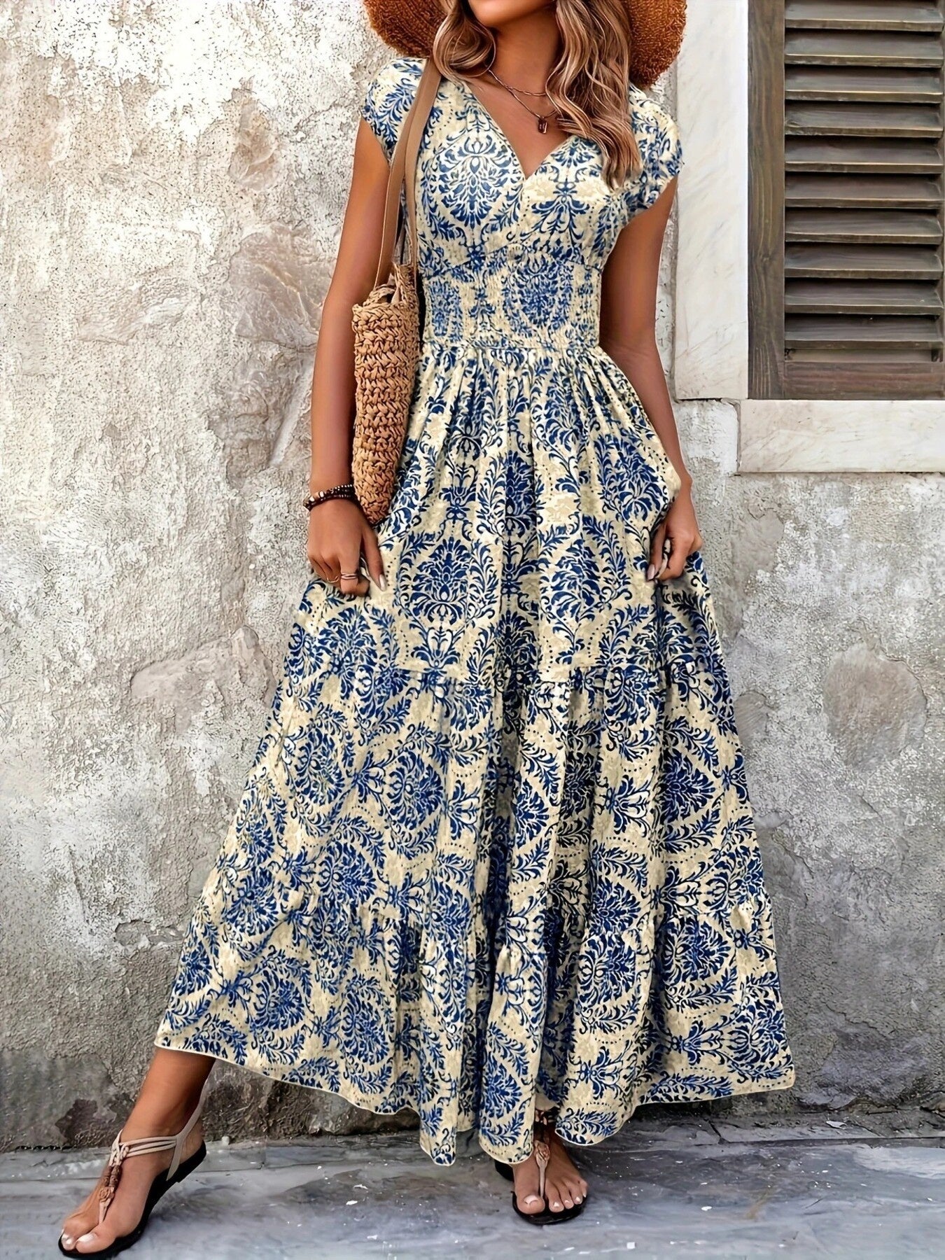 Printed cap-sleeve maxi dress in beige with blue floral print; tiered, smocked bodice.