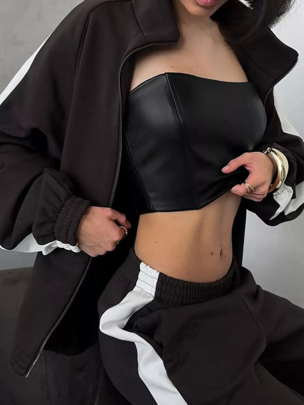 Belle Bijouix two-piece activewear set: black zip-up jacket with long sleeves and pants with white stripe