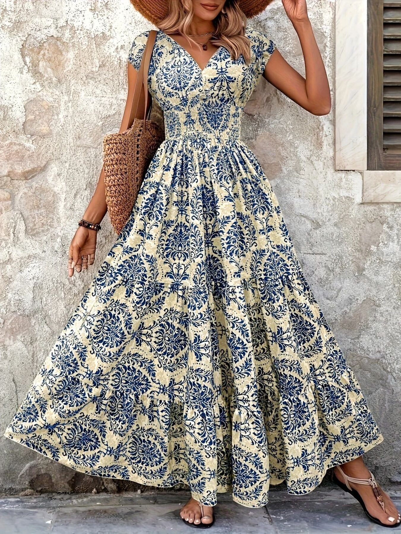Printed cap-sleeve maxi dress in blue on cream with tiered, smocked bodice.