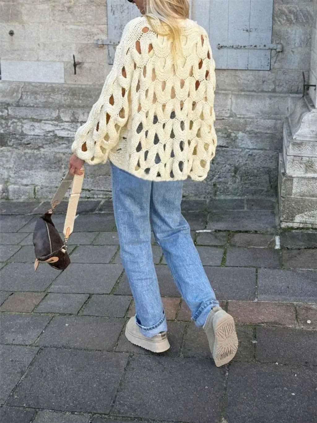 Chunky cable-knit hollow-out sweater in cream; oversized knit with cutouts.