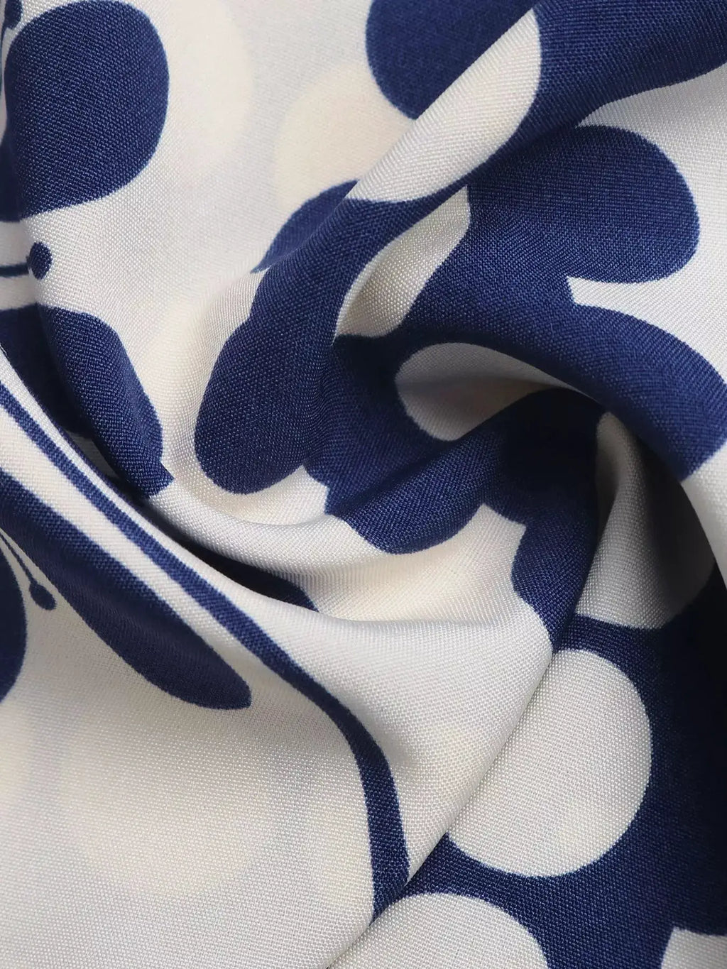 Dresses navy blue floral print fabric on white; close-up woven texture.