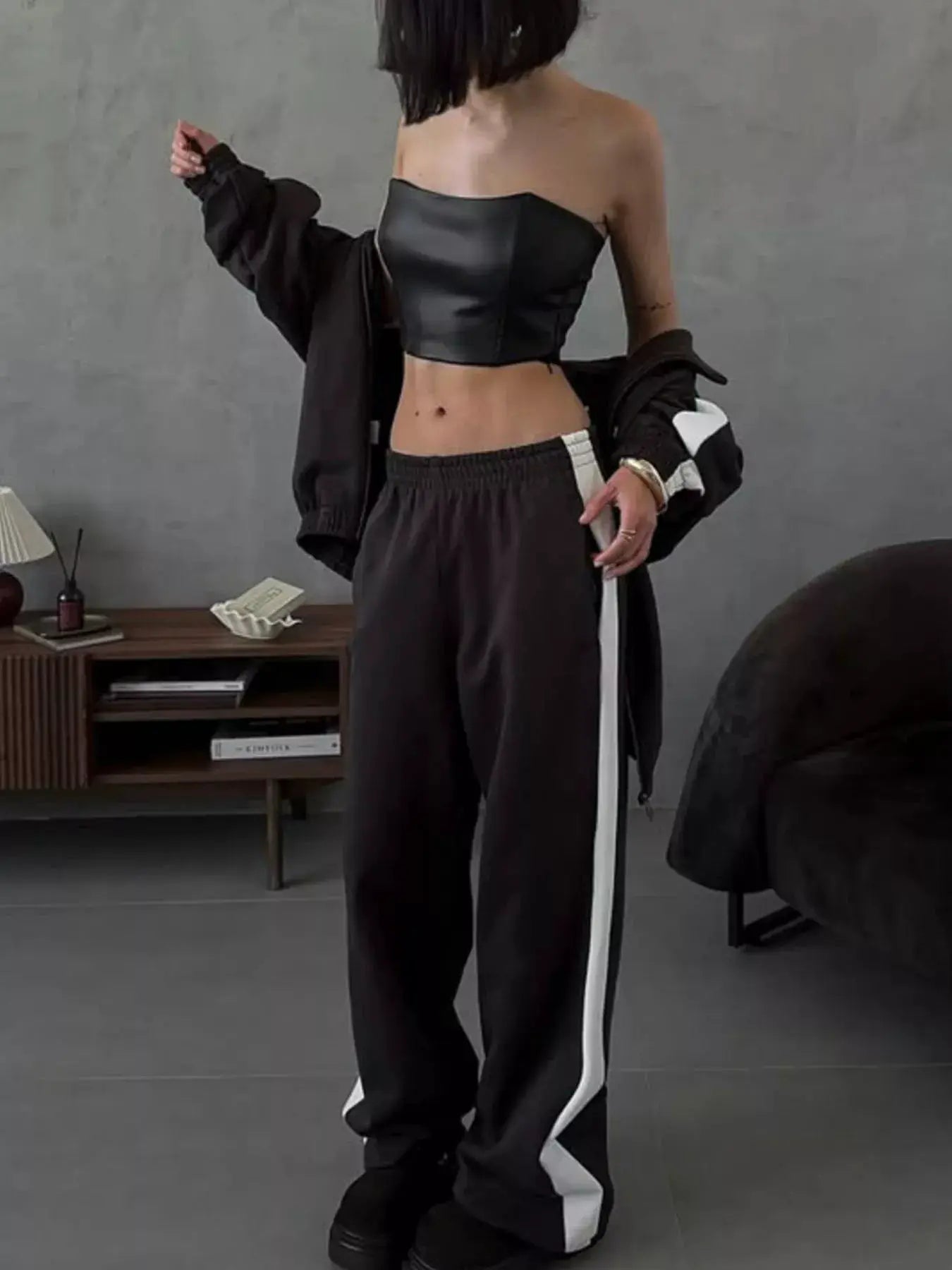 Two-piece black activewear set with zip-up outerwear and pants with a white side stripe