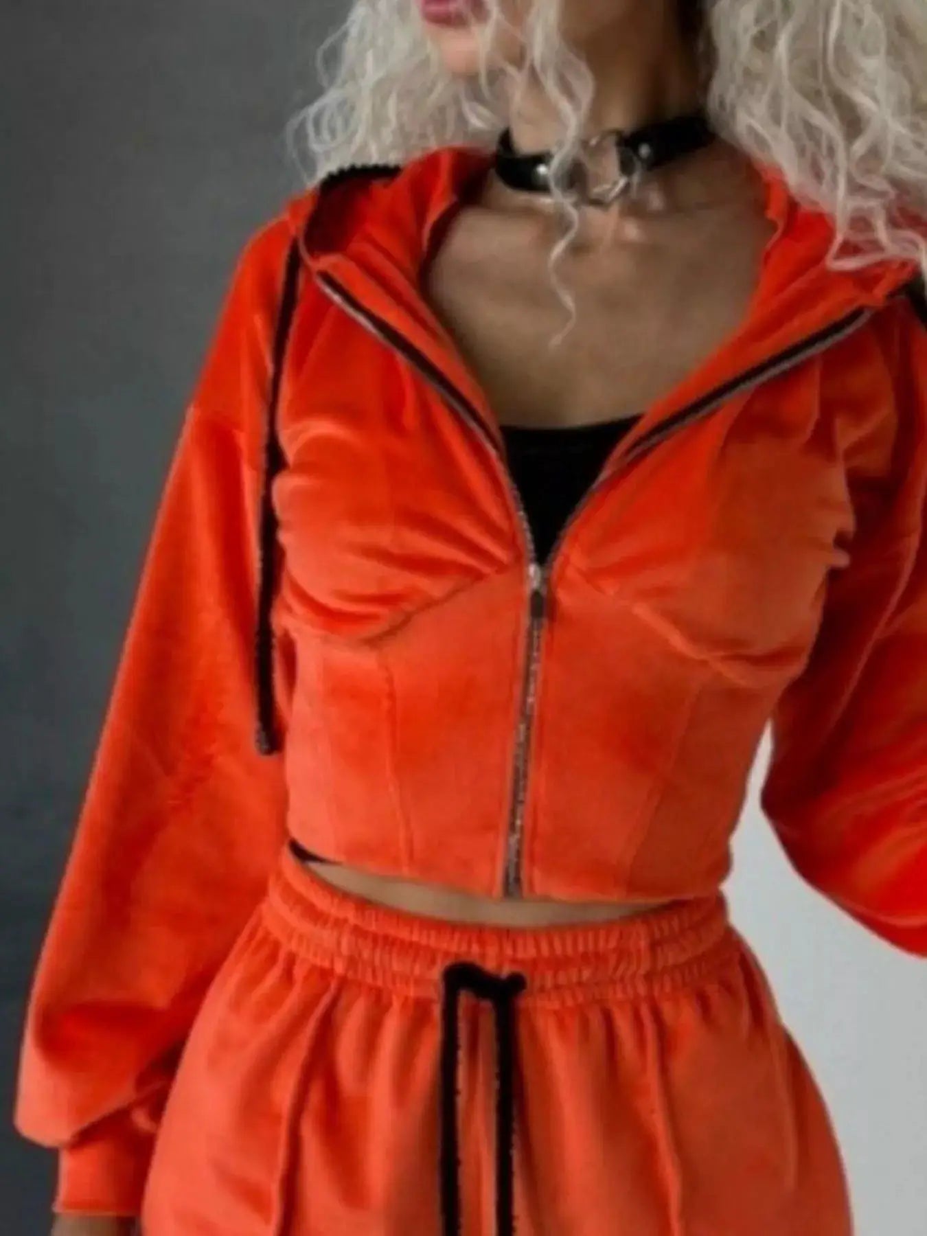 Two-piece orange zip-up hooded activewear set by Belle Bijouix with matching shorts and black piping.
