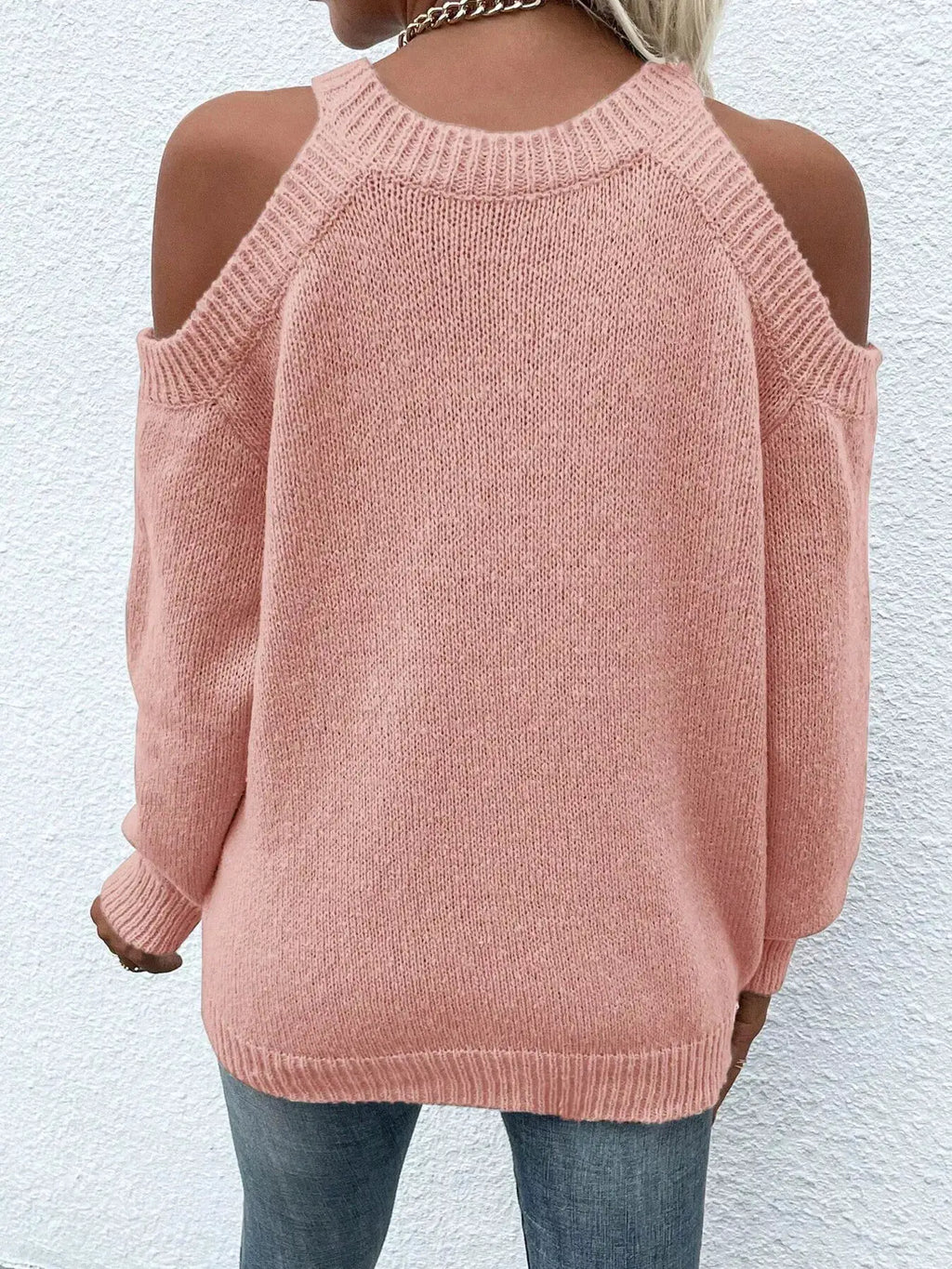 Cold shoulder knit sweater in pink, back view with exposed shoulders and ribbed cuffs