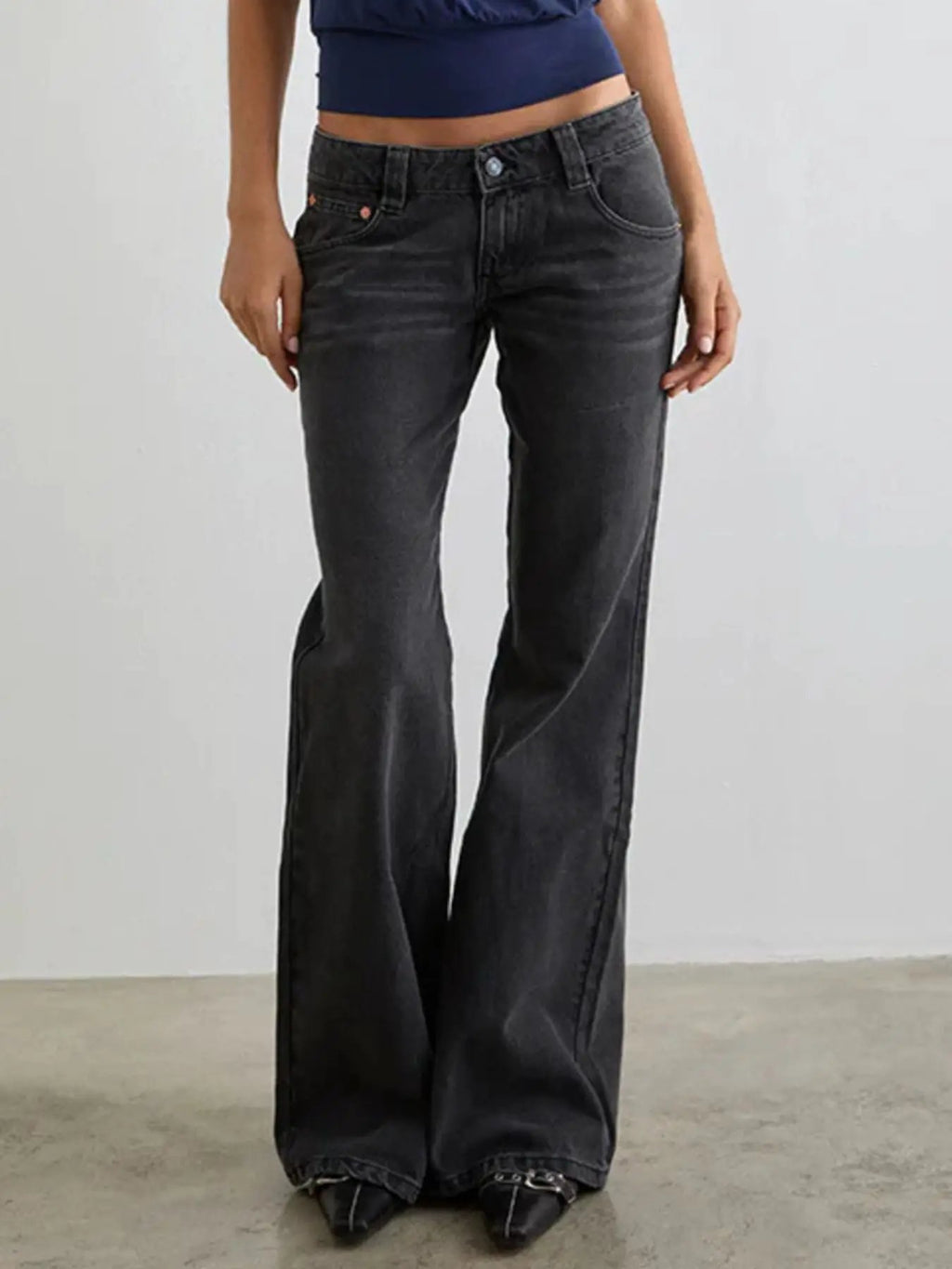 Low Rise Flare Leg Jeans by Belle Bijouix in dark denim with copper rivet accents, five pockets and button closure.
