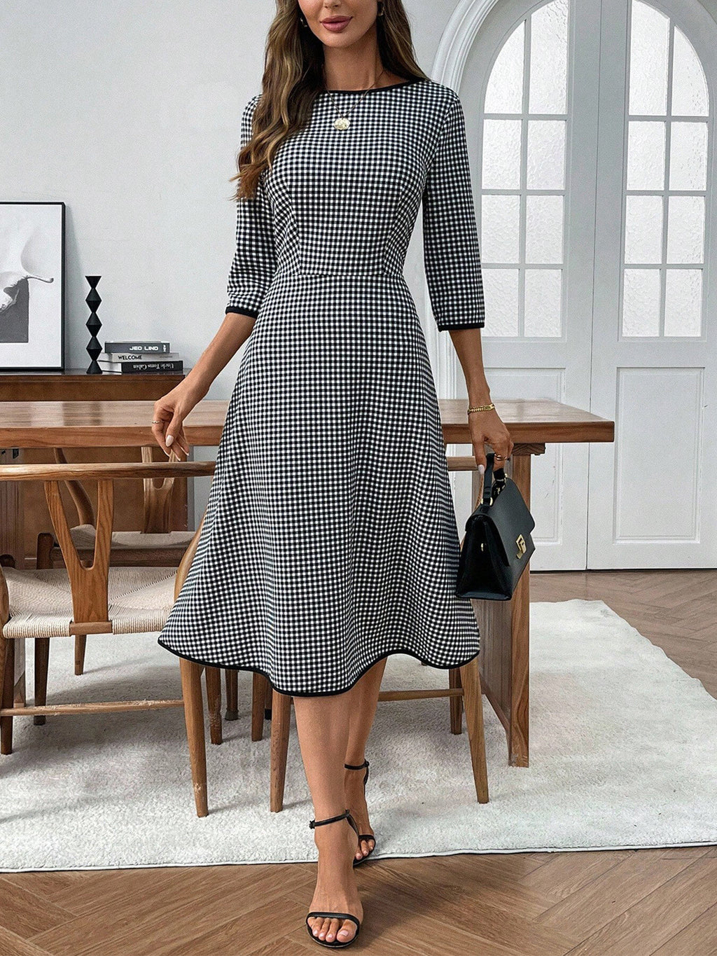 Plaid round-neck 3/4-sleeve dress in black and white gingham, knee-length.
