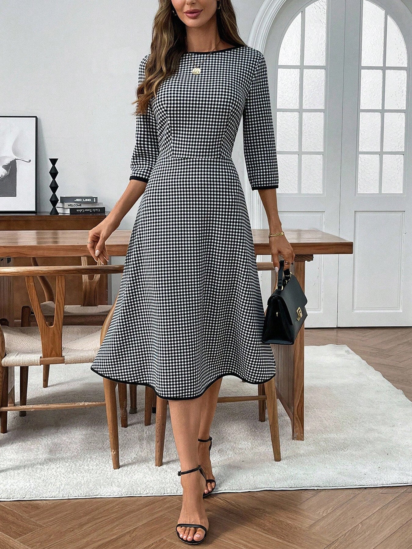Plaid round-neck 3/4-sleeve dress in black and white gingham, knee-length.