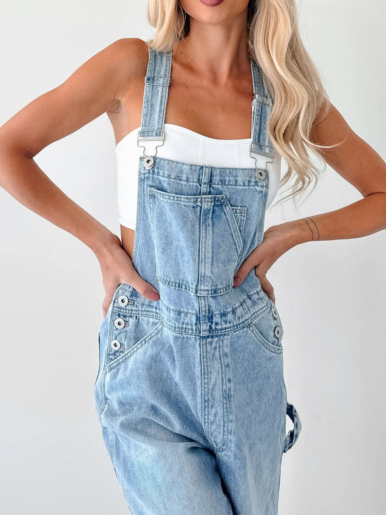 Wide Strap Relaxed Fit Denim Overalls in light wash with metal buckle straps, worn over a white top.
