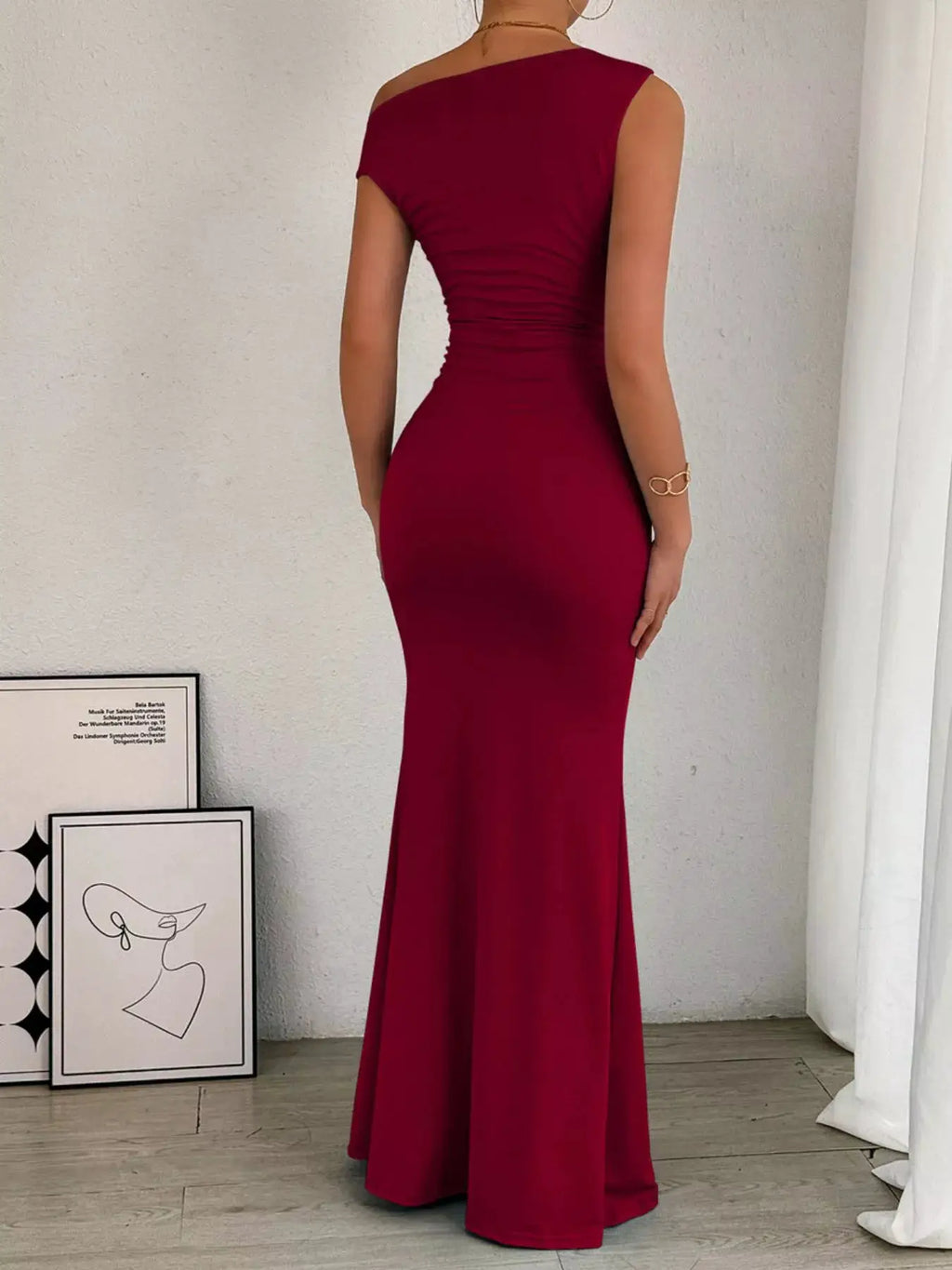 One-shoulder burgundy ruched bodycon maxi dress, back view with a sleek fitted silhouette and floor-length hem