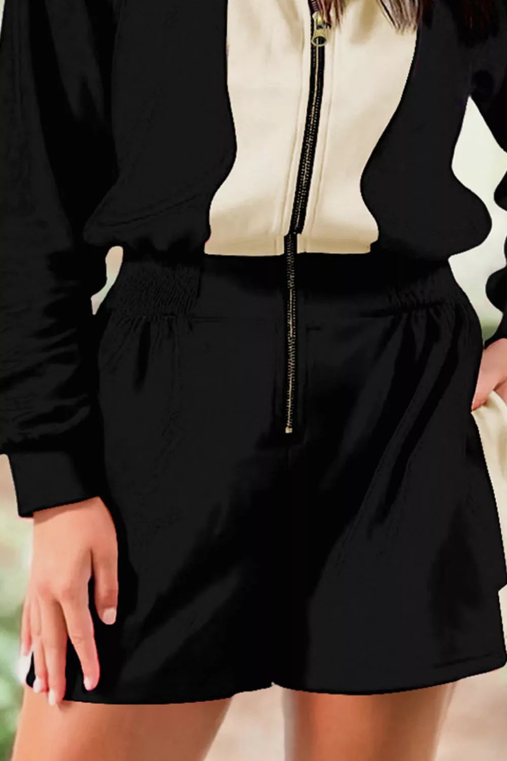 Two-Tone Zip-Up Romper by Belle Bijouix, black with beige zipper detail.