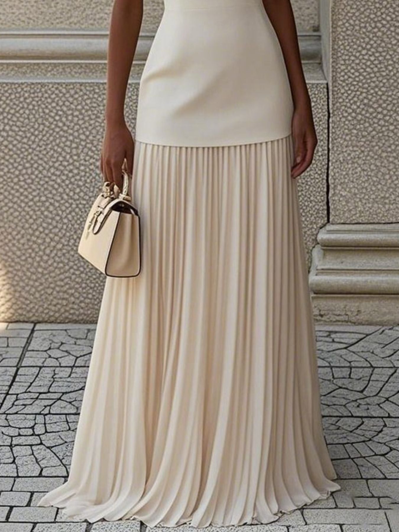 Sleeveless pleated maxi dress in ivory with a smooth bodice and flowing pleated skirt