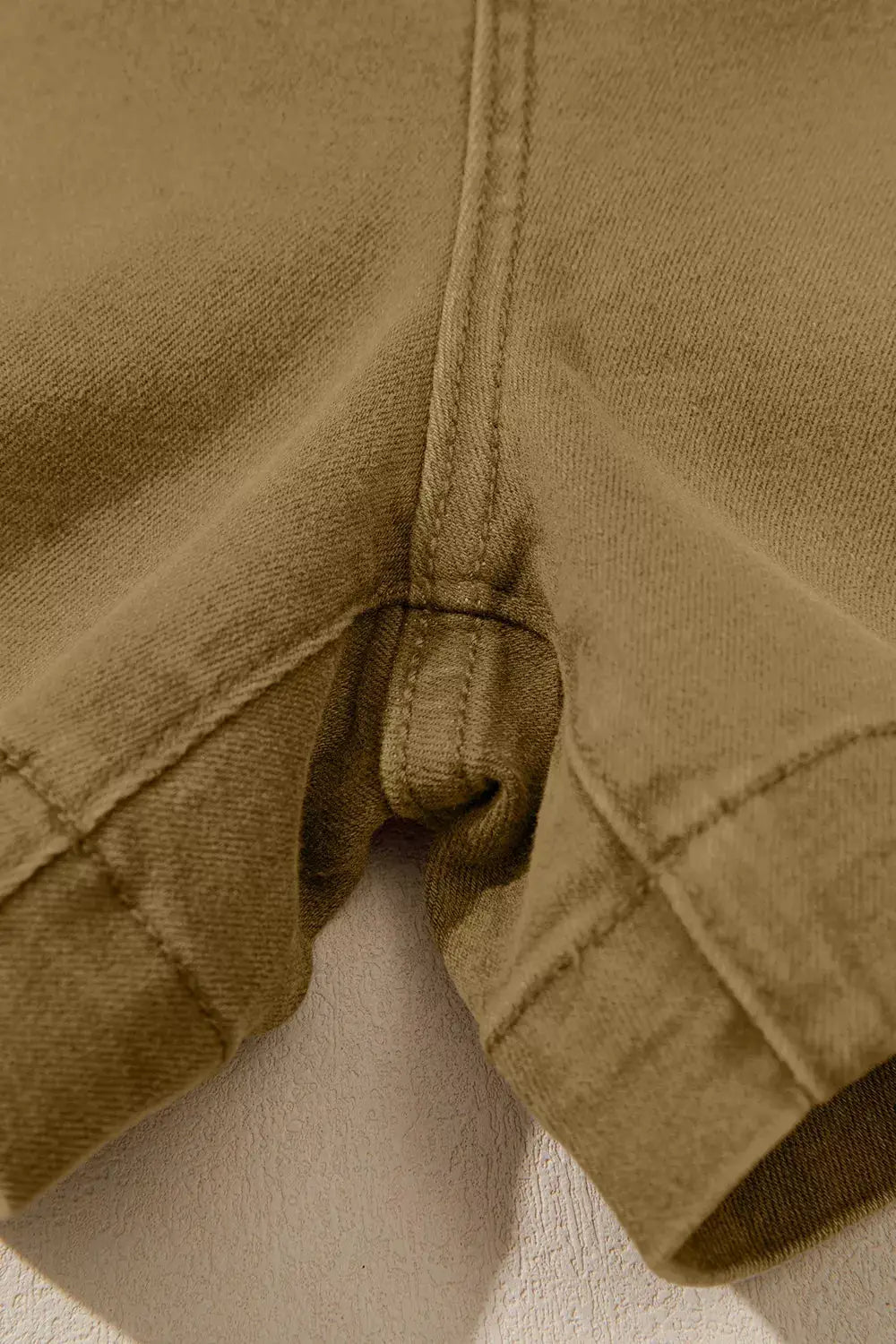 Women's Western Denim Shorts, tan denim fabric; close-up of seam and folded hem.