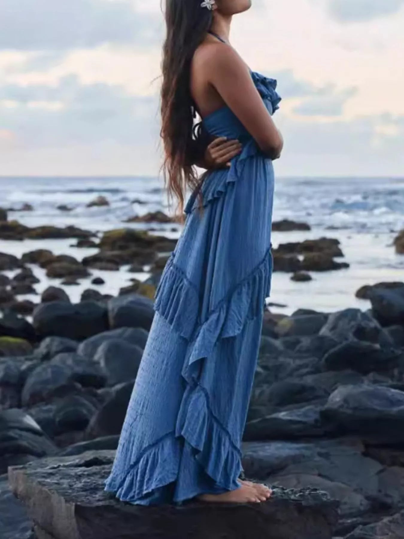 Ruffled halter-neck blue maxi dress with tiered skirt on model at the beach