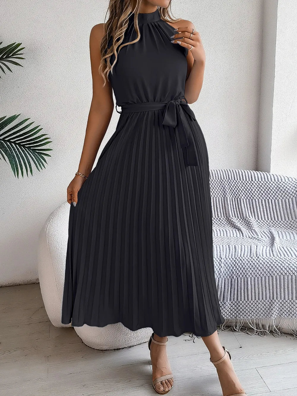 Pleated tie-waist sleeveless midi dress in black by Belle Bijouix.