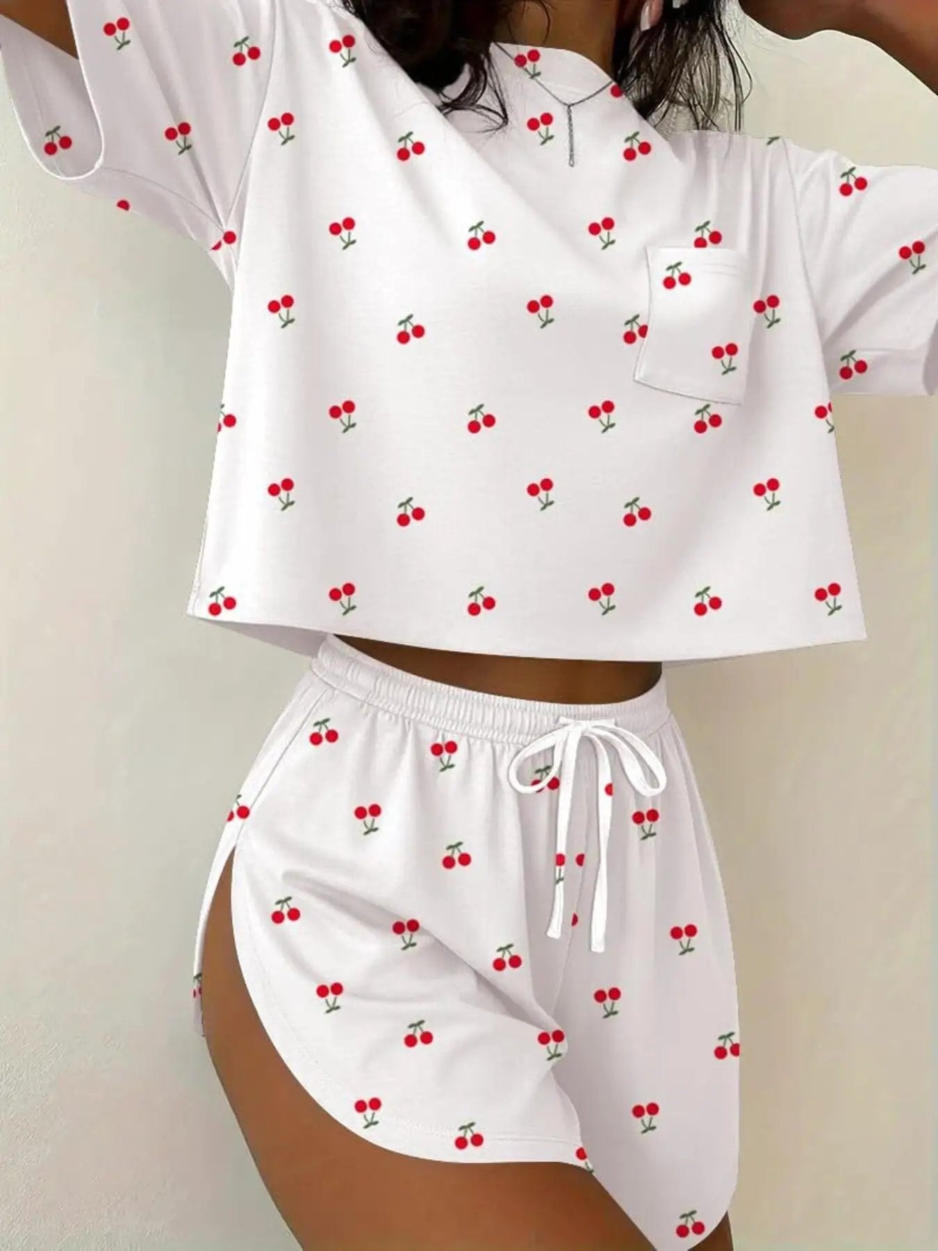 Printed cherry-pattern two-piece round-neck tee and shorts set in white with red cherries.
