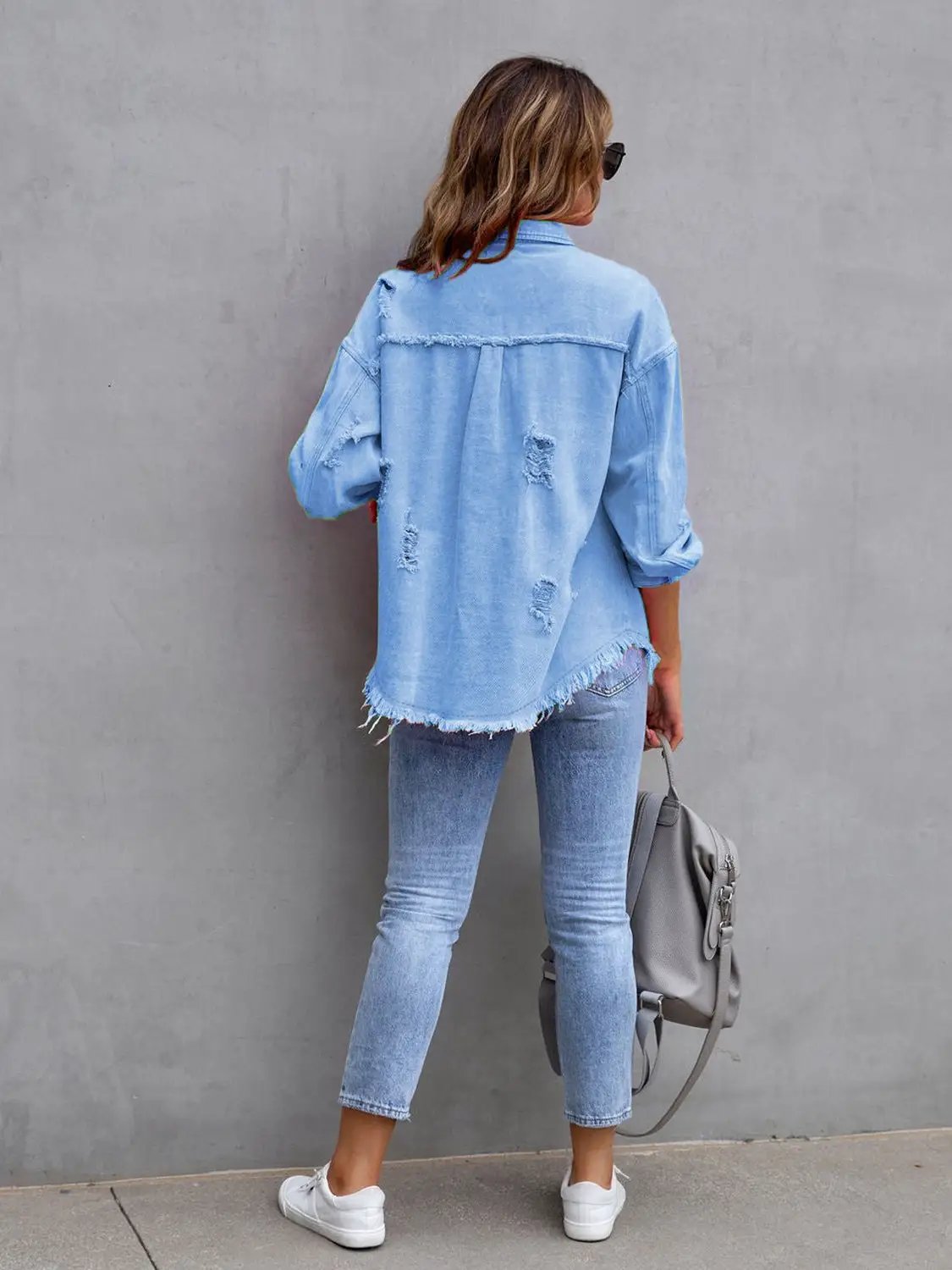 Distressed Drop Shoulder Denim Jacket in light blue with frayed hem.