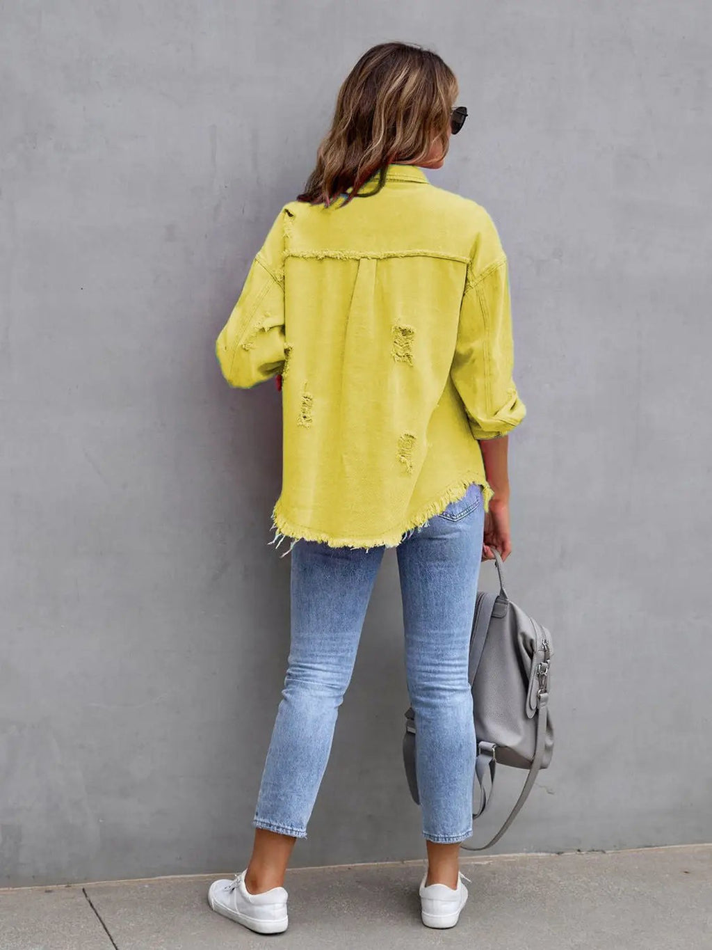 Distressed drop-shoulder denim jacket in yellow with frayed hem and ripped patches