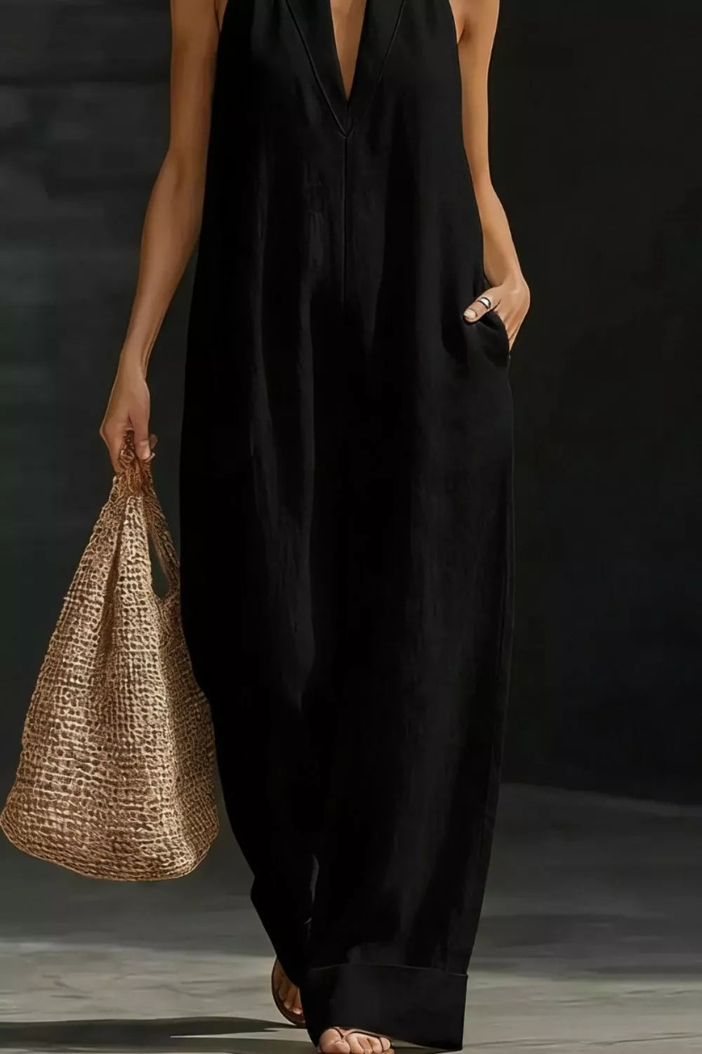 Sleeveless black wide-leg jumpsuit with deep V-neck and pockets.