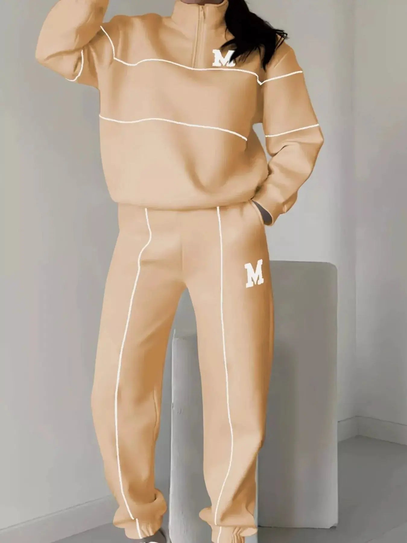 Plus-size peach quarter-zip activewear set with white piping and M logos on chest and leg