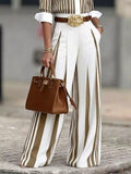 High-waisted wide-leg striped pants in white with tan stripes, paired with a brown belt and gold buckle.