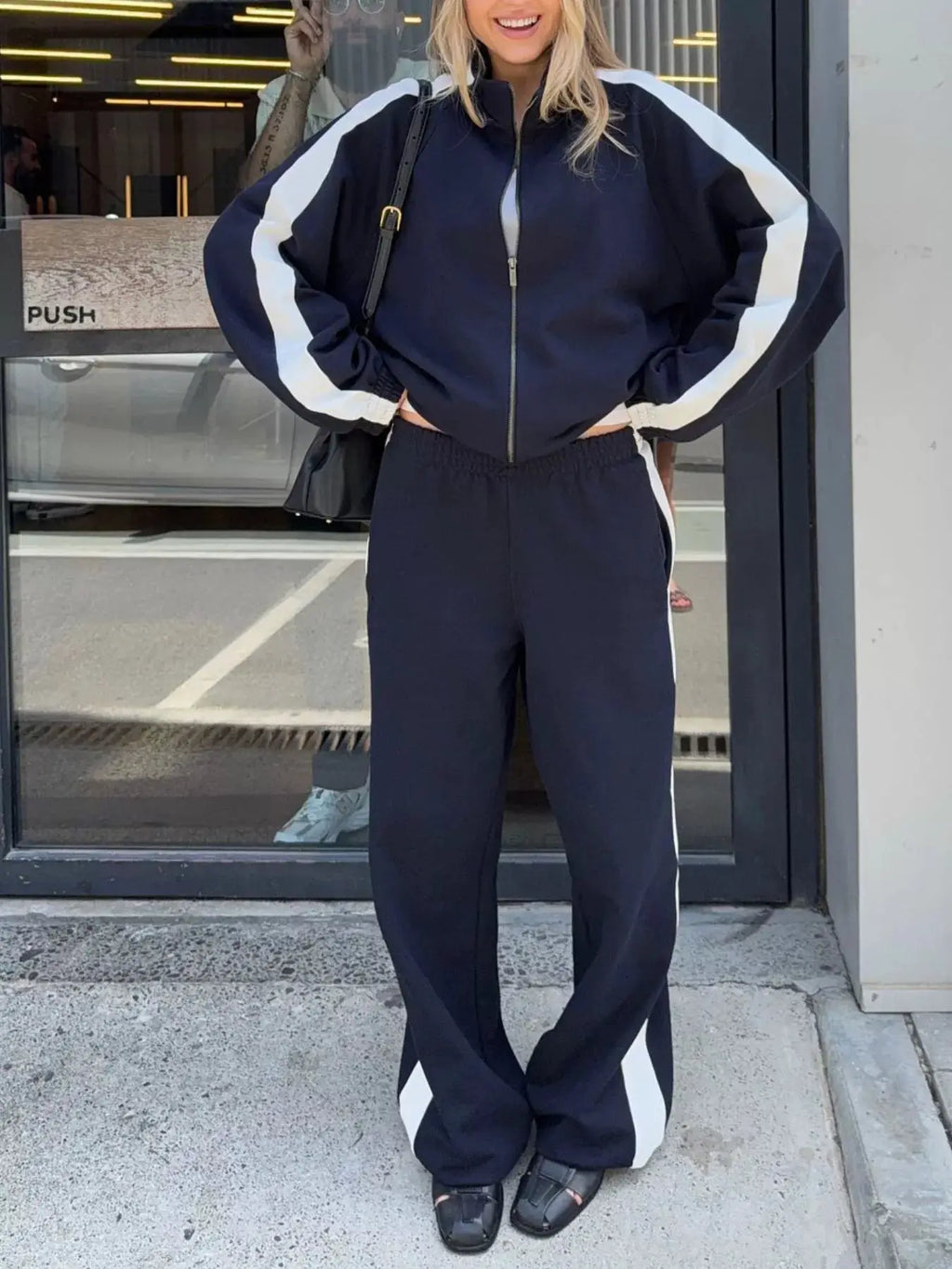 Belle Bijouix navy two-piece zip-up activewear jacket and pants set with white stripe panels