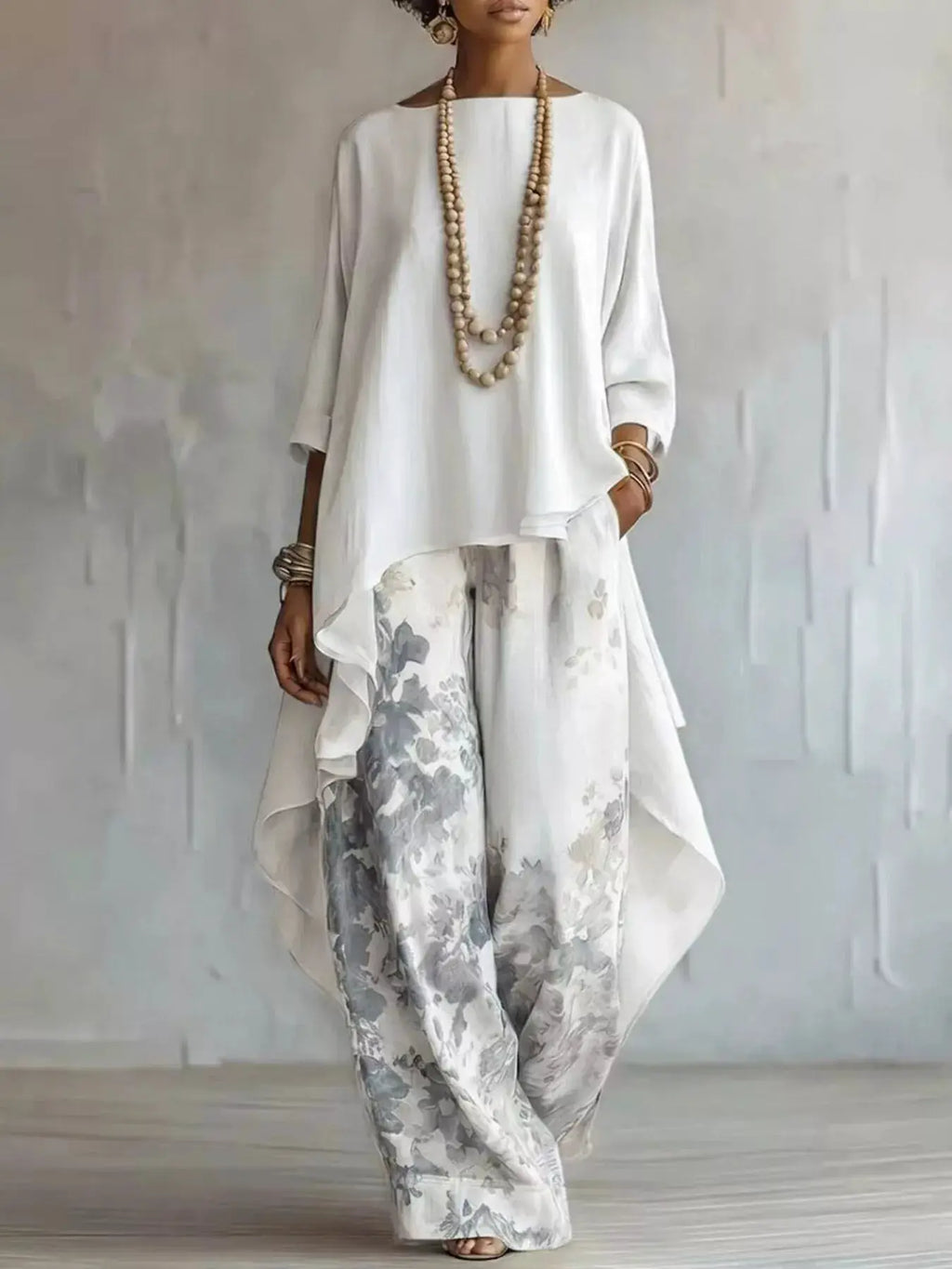 Outfit set: Asymmetrical Hem Top and Floral Pants by Belle Bijouix, ivory top with gray floral pants.