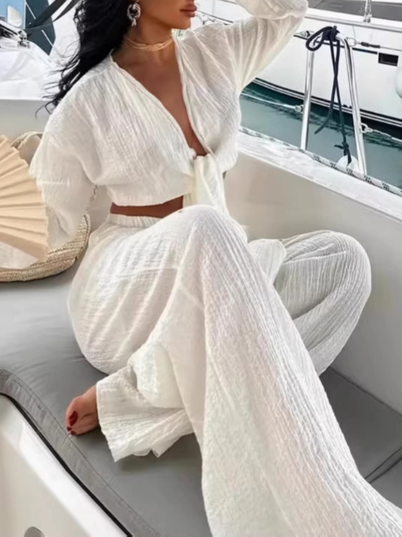 Textured tie-front crop top and wide-leg pants set in white by Trendsi; model on a boat.