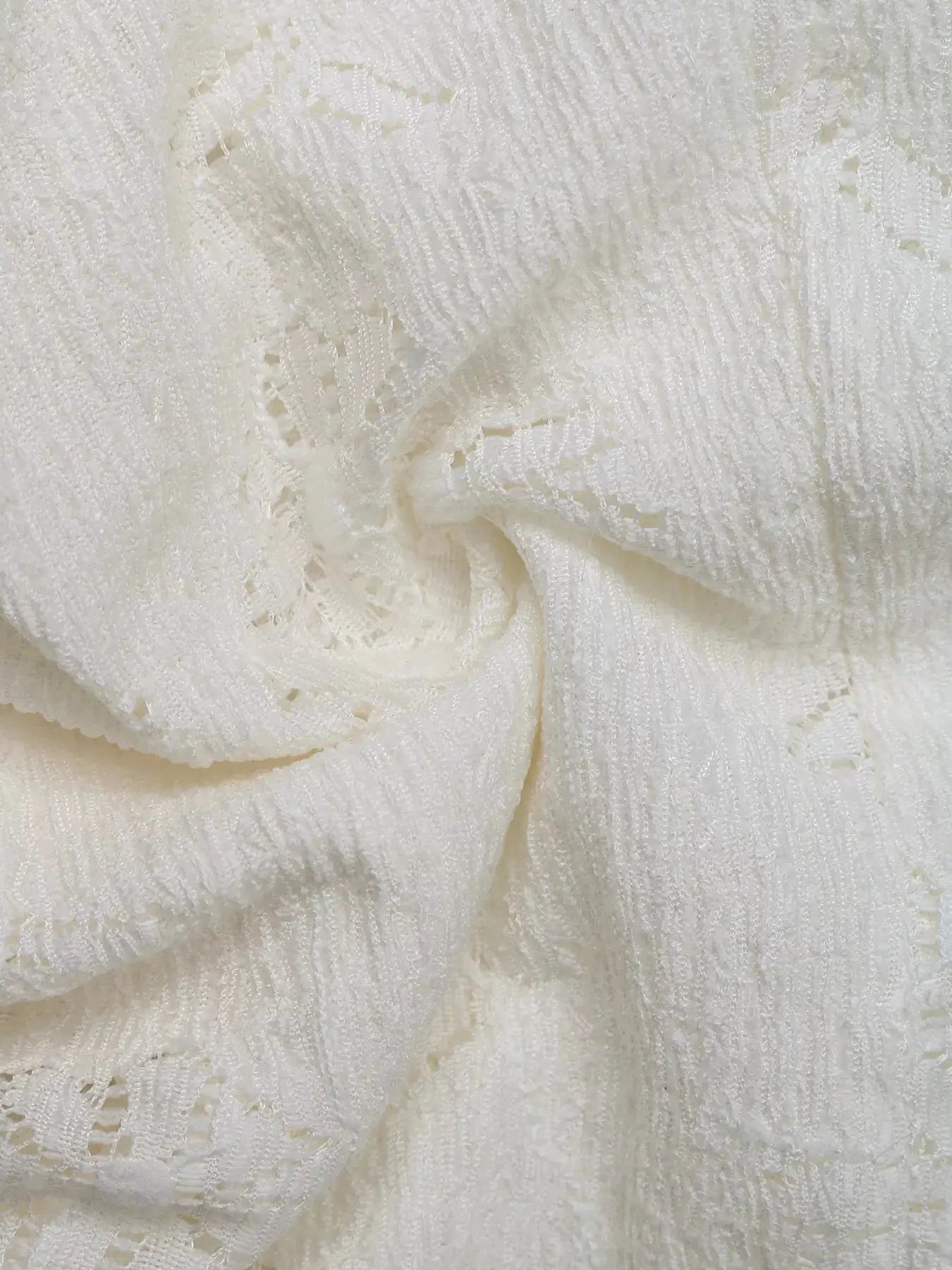 White lace cami fabric close-up showcasing delicate textured pattern